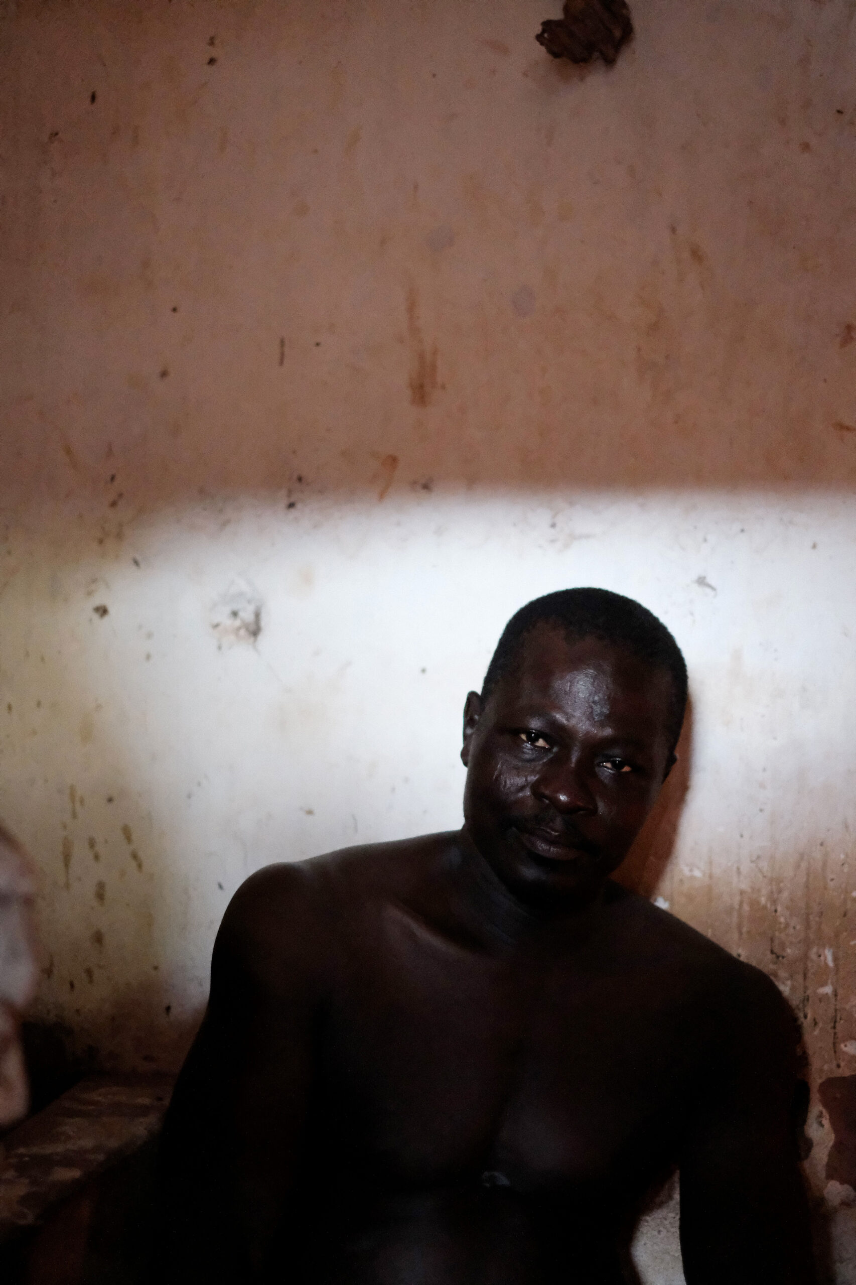 A voodoo practitioner seated in a contemplative pose in Adjarra Benin on December 20 2022. The moment reflects the meditative aspect of voodoo practices. Un praticien vaudou assis dans une pose contemplative a Adjarra au Benin le 20 decembre 2022. Le moment reflete l'aspect meditatif des pratiques vaudoues.